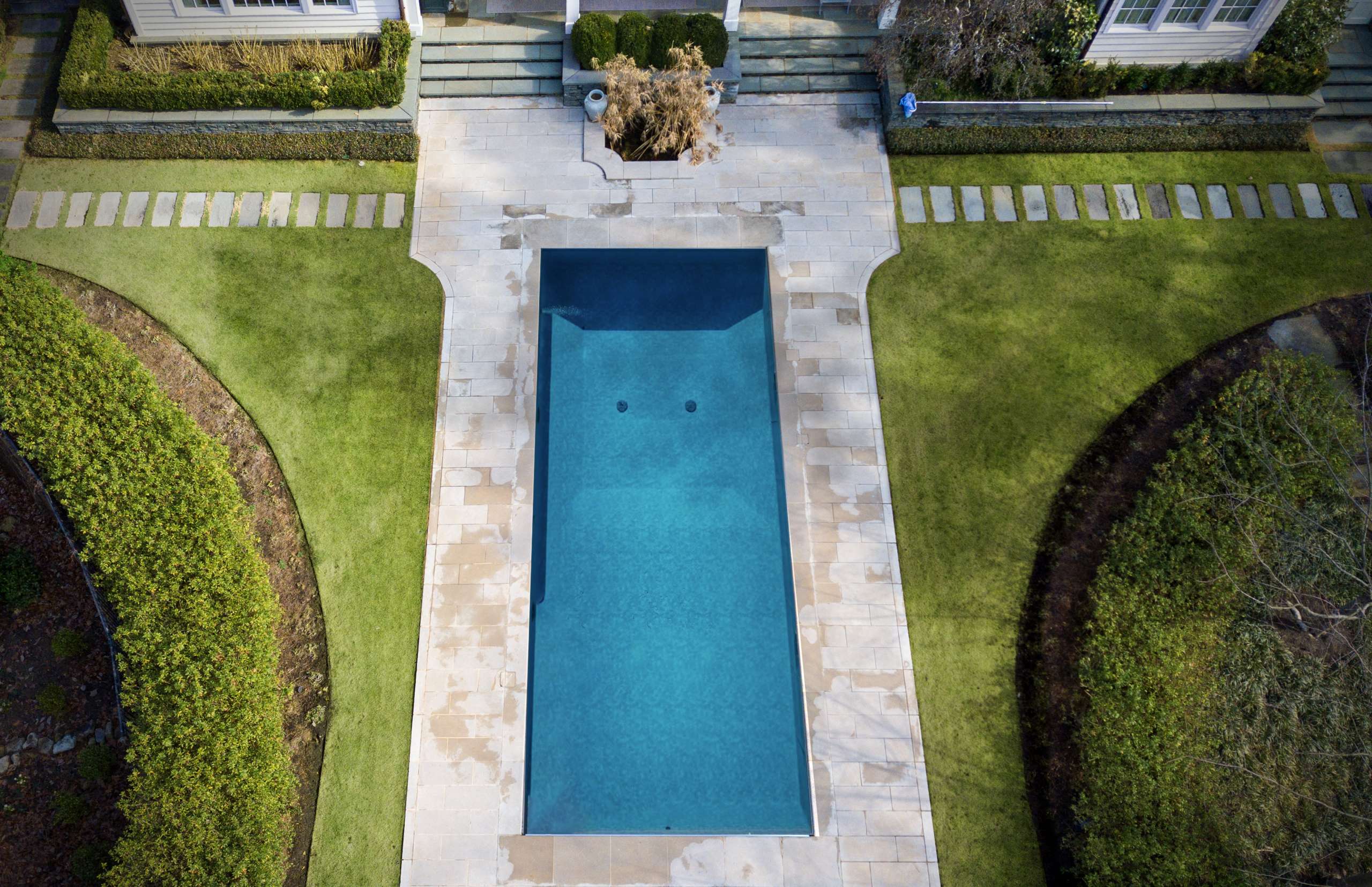 Rectangular pool with natural stone paver coping and manicured lawn surround