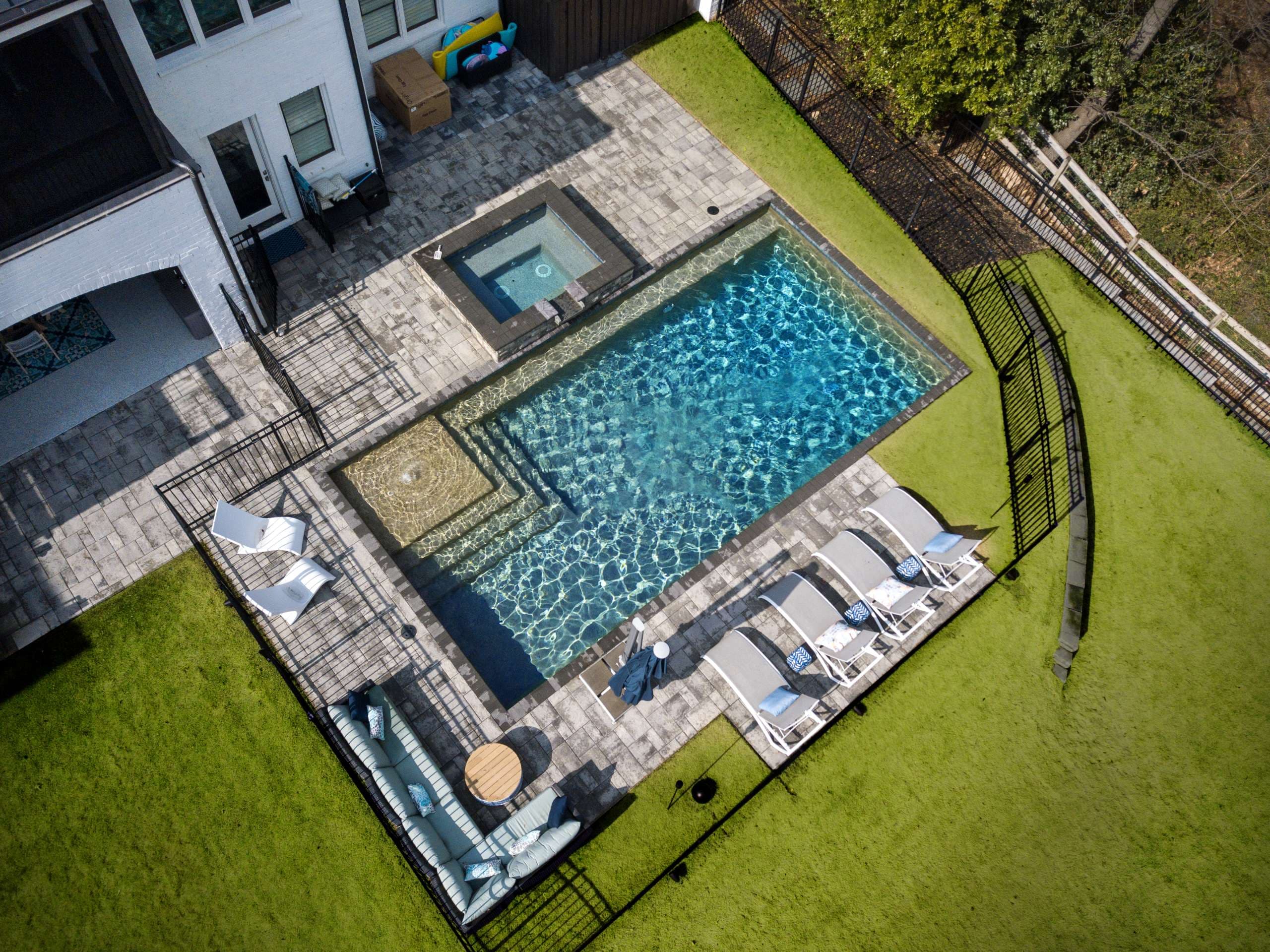 Modern rectangular pool with spa and paver deck with tanning ledge in Atlanta