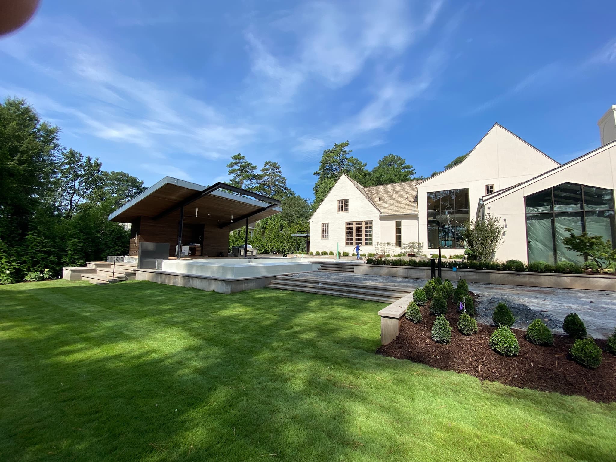 Modern pool house with stone deck and landscaping at ground level